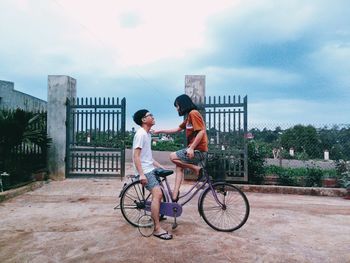 Man riding bicycle on road against sky