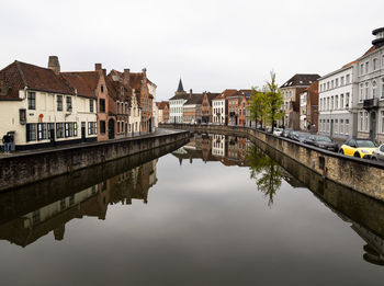 Reflection of buildings in city against clear sky