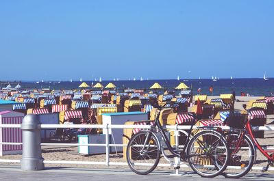 Bicycle parked by hooded chairs at beach