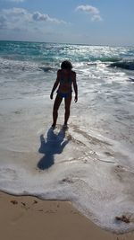 Full length of boy on beach against sky