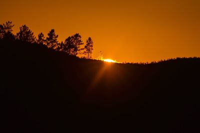 Silhouette trees against sky during sunset