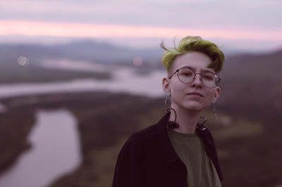 Portrait of woman looking away against sky during sunset