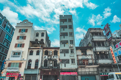 Low angle view of buildings against cloudy sky