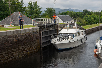 People on boat in canal against sky