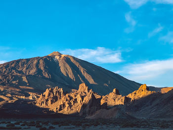 Scenic view of mountains against blue sky