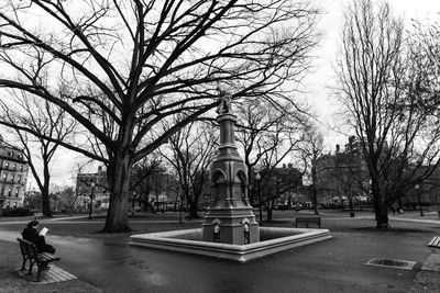 Statue in city against sky