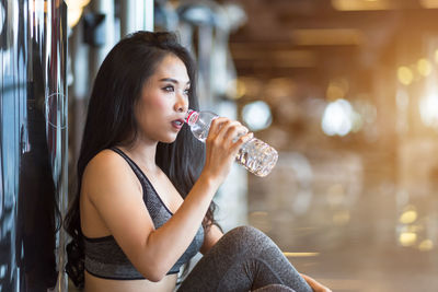 Portrait of a young woman drinking glass