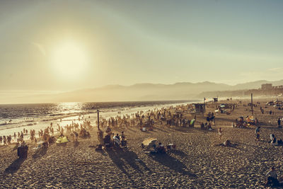 People at beach during sunset