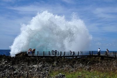 Panoramic shot of waves splashing against sky