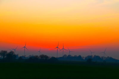 Silhouette windmill working at sunset