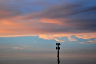 Low angle view of communications tower against sky during sunset