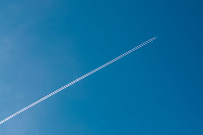 Low angle view of vapor trail in blue sky