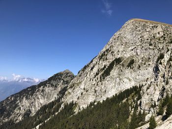 Low angle view of snowcapped mountain against blue sky