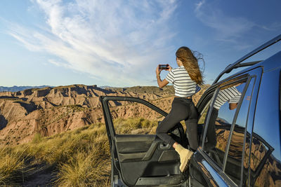 Rear view of woman standing on road against sky