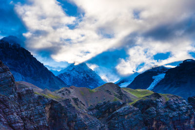 Scenic view of snowcapped mountains against cloudy sky