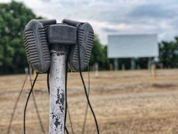 Close-up of metal structure on field against sky