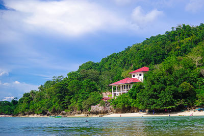 Houses by sea against sky