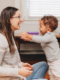 Smiling mother and son playing at home