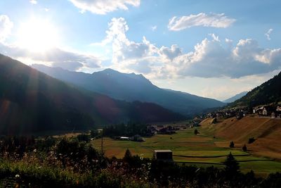 Scenic view of field and mountains against sky