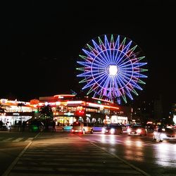 Illuminated ferris wheel against sky at night