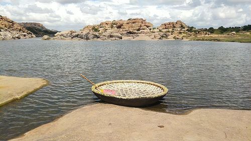 Scenic view of rocks by river against sky