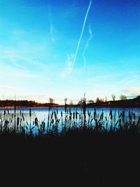 Scenic view of silhouette landscape against blue sky