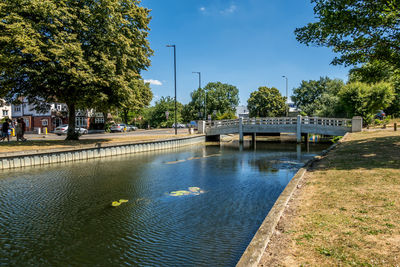 Bridge over river in city against sky