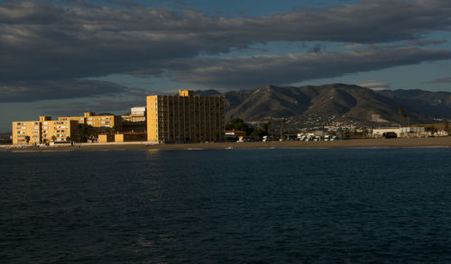 Buildings by sea against sky in city