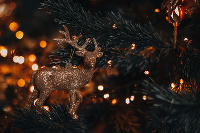 Retro golden christmas toy figurine of a deer hanging on a christmas tree. magic winter