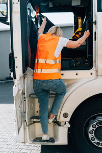 Rear view of man working in car