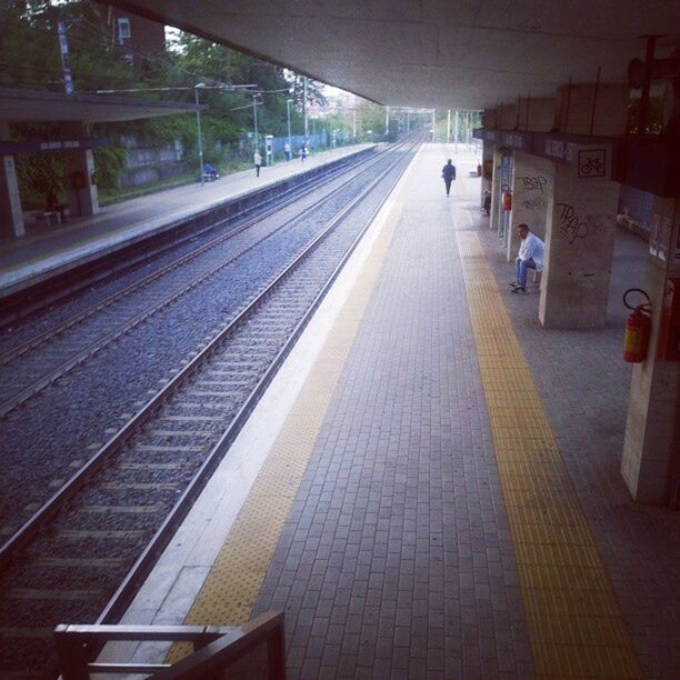 railroad track, indoors, railroad station platform, transportation, rail transportation, public transportation, railroad station, the way forward, diminishing perspective, built structure, illuminated, architecture, vanishing point, incidental people, empty, subway station, travel, public transport, subway, train - vehicle