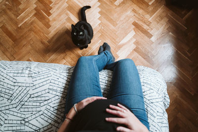Young pregnant woman at home. beautiful black cat besides