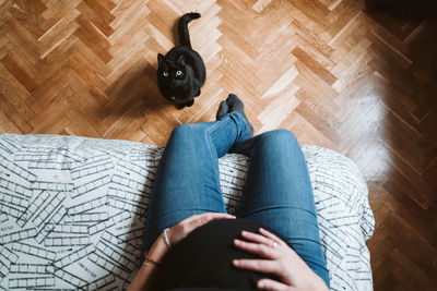 Low section of woman sitting on hardwood floor