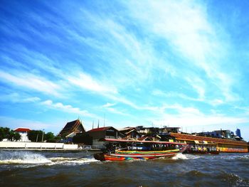 Buildings by sea against sky