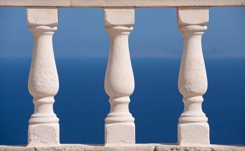 Close-up of white wall against blue sky