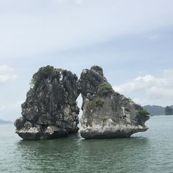 Rock formation in sea against sky