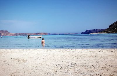 Rear view of woman in sea against clear sky