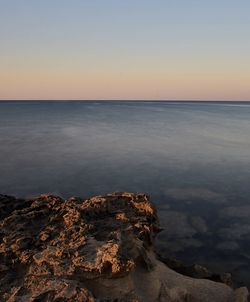 Scenic view of sea against clear sky at sunset