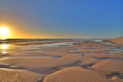 Scenic view of beach against sky during sunset