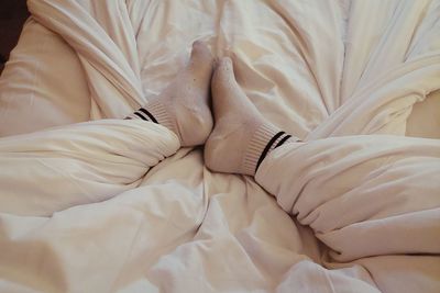 Close-up of woman feet on white bed