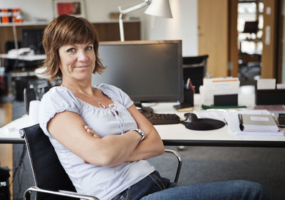 Portrait of smiling mature business woman with arms crossed