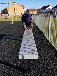 Boy playing on bench at park