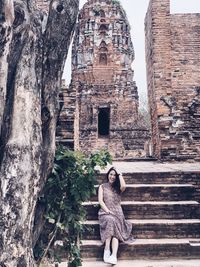 Full length of woman sitting outside temple