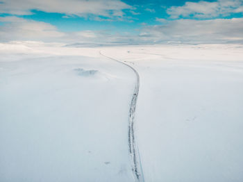 Snow covered land against sky