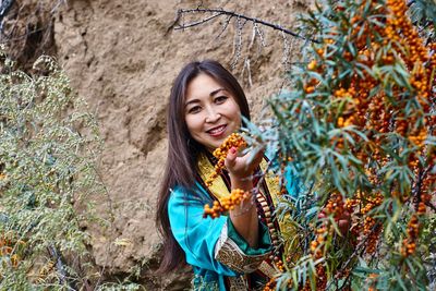 Portrait of smiling woman by fruit tree