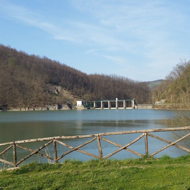 water, railing, mountain, lake, tranquil scene, sky, tranquility, river, tree, scenics, beauty in nature, nature, fence, grass, landscape, built structure, day, bridge - man made structure, mountain range, idyllic