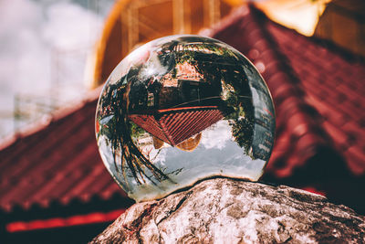 Reflection of building in crystal ball on rock