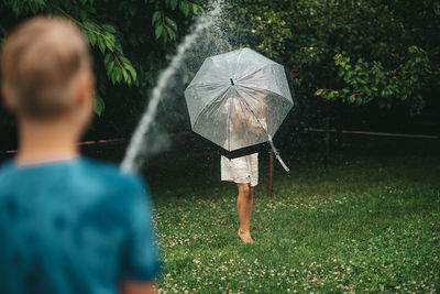 Rear view of man holding umbrella