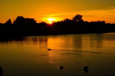 Scenic view of lake against orange sky