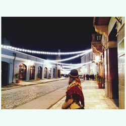 Full length of woman in illuminated city at night